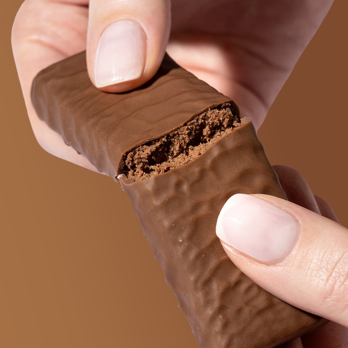 ProteinRiegel_Brownie_06-min 30% Protein Riegel Brownie – Hände die einen zerbrochenen Riegel halten | Aldi Sports