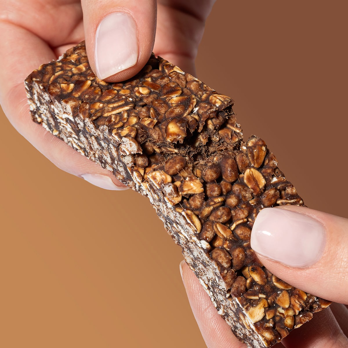 EnergyRiegel_CacaoCrunch_06-min Energy Riegel Cacao Crunch – Hände die einen zerbrochenen Riegel halten | Aldi Sports