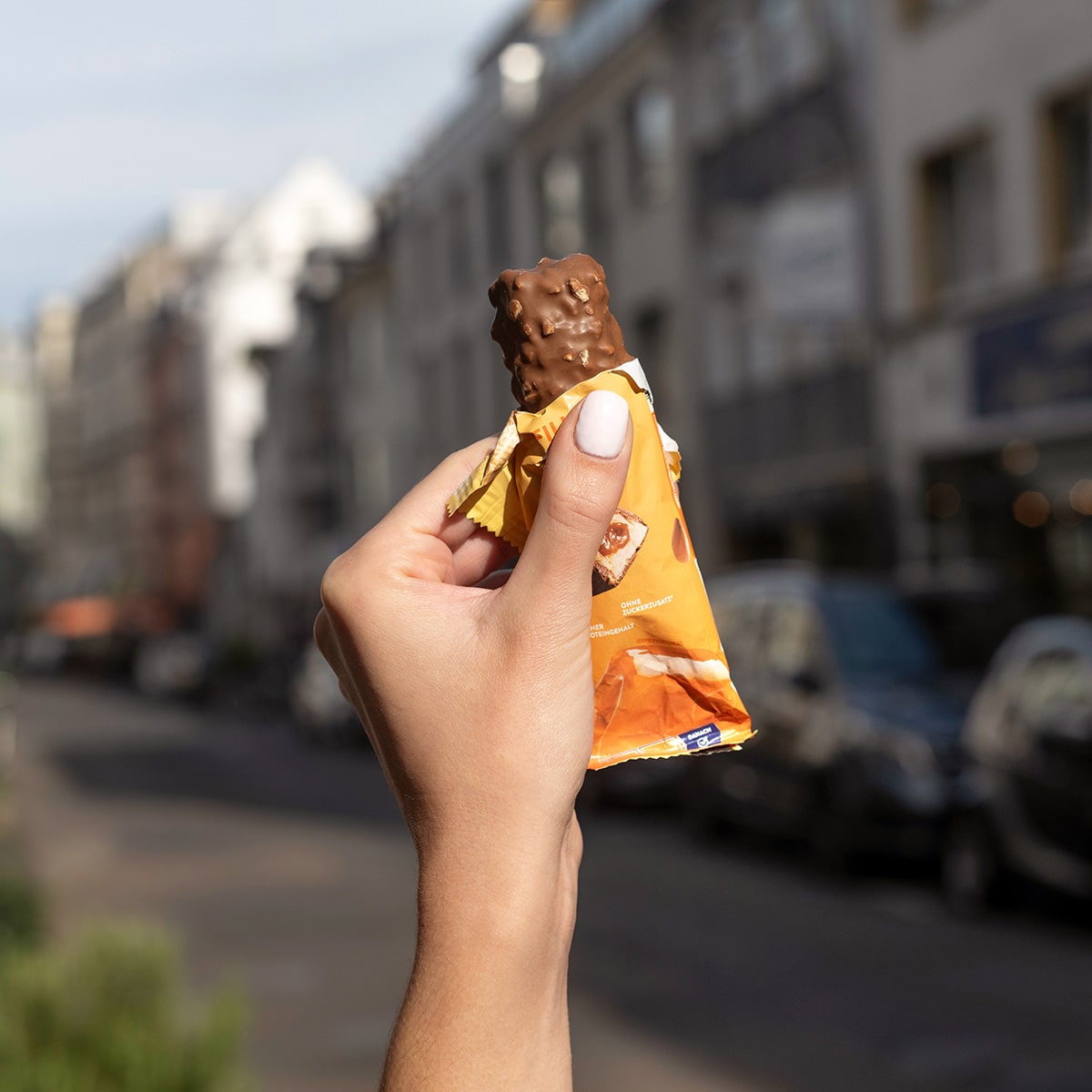 FilledProteinRiegel_PeanutCaramel_05-min Filled Protein Riegel Peanut Caramel – Eine Hand hält den geöffneten Riegel | Aldi Sports