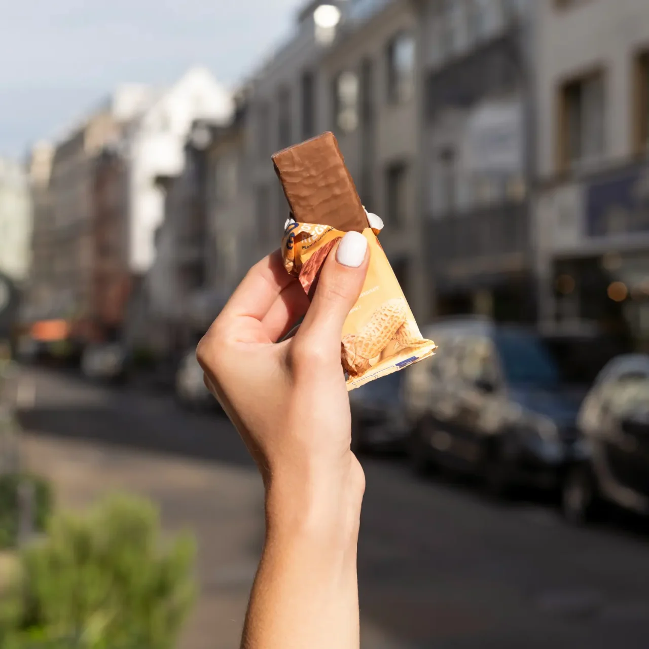 ProteinRiegel_Peanut_05 50% Protein Riegel Peanut – Eine Hand hält den geöffneten Riegel | Aldi Sports