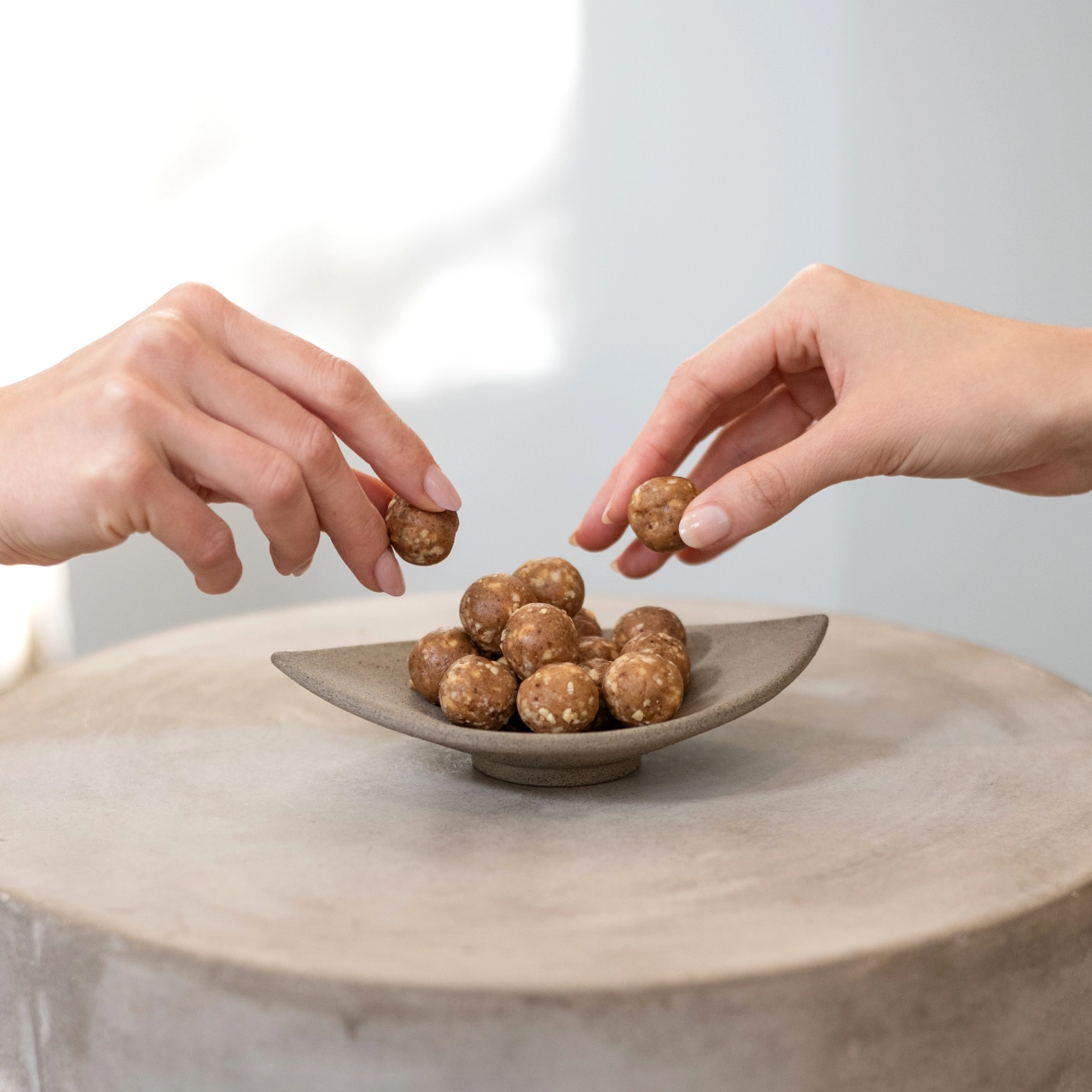 Energy Balls Peanut Butter_05 Whey Protein Balls Peanutbutter – Proteinbälle auf einem Teller, Hände greifen danach | Aldi Sports