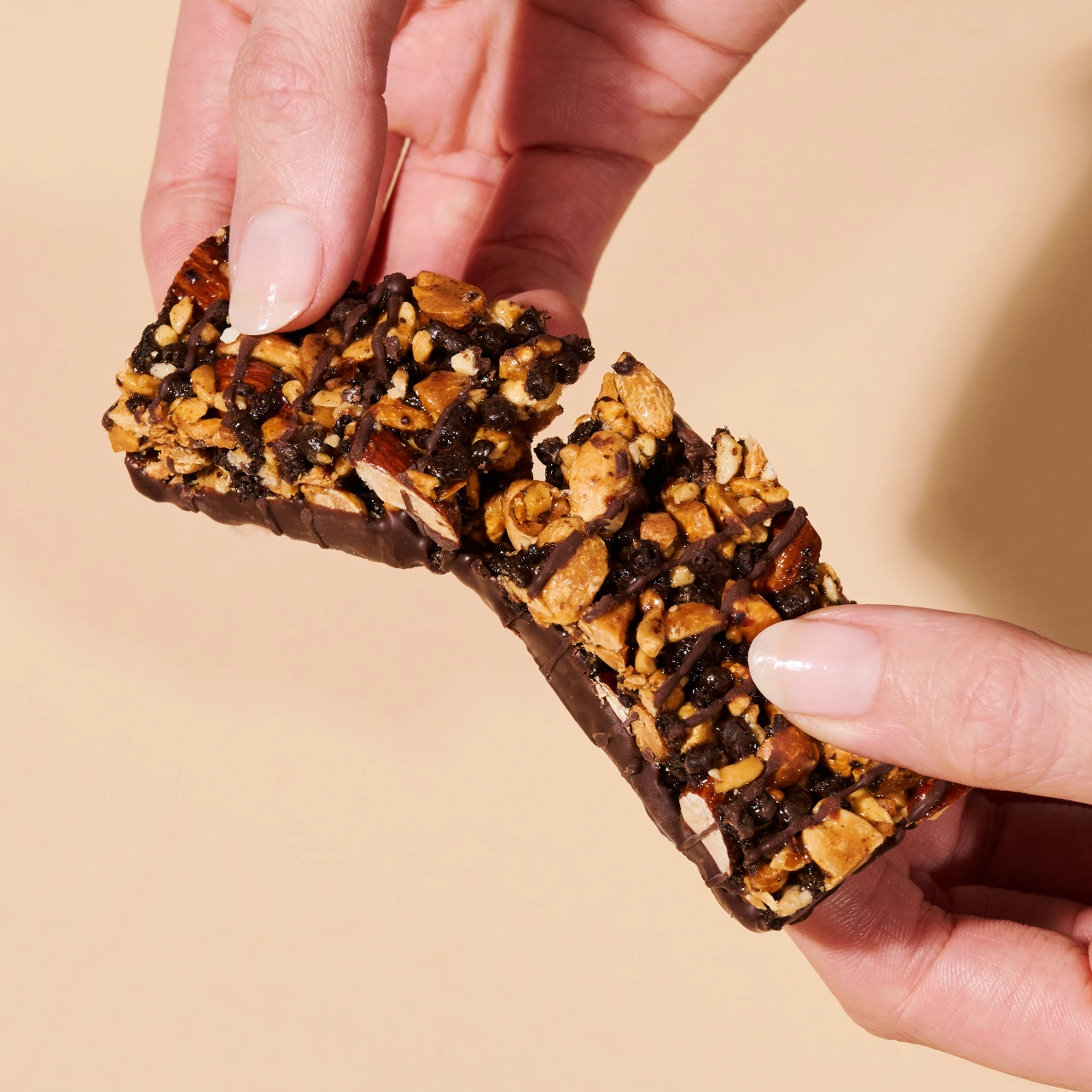 Erdnuss Protein Riegel Dark Chocolate_04 Erdnuss Protein Riegel Dark Chocolate Peanut – Hände die einen zerbrochenen Riegel halten | Aldi Sports